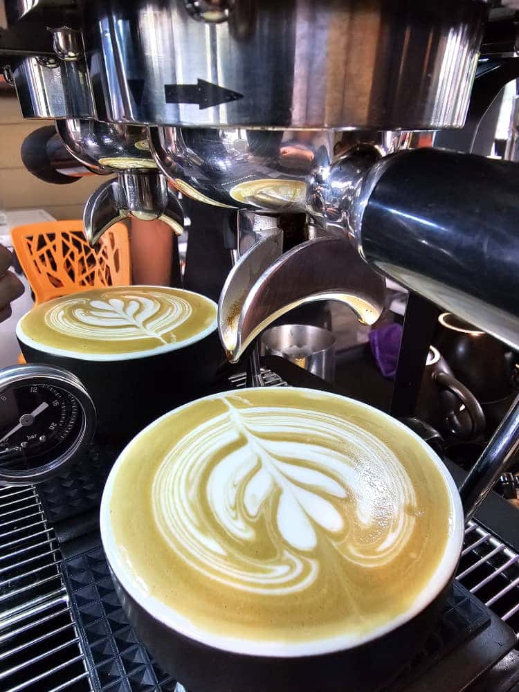 Latte art baru dituang di bawah mesin espresso